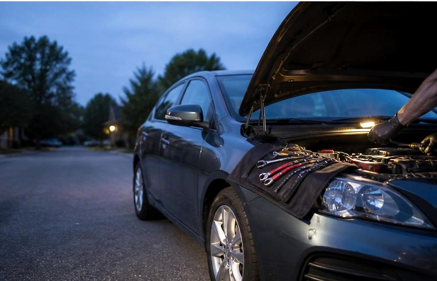 Lake Charles mobile mechanic working under lights at a neighborhood curb
